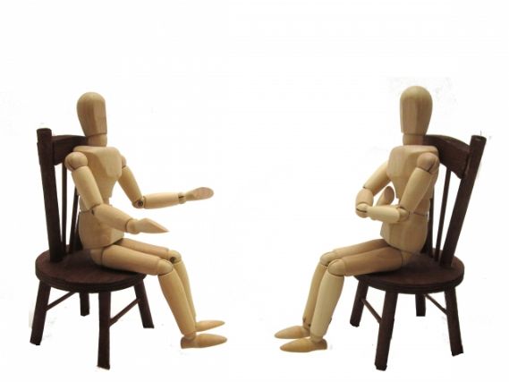 椅子に座り話す人形