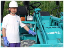 しのはら土を採掘している鉱山機械の前で撮影 《橋鉱山内⇒ヘルメット着用》