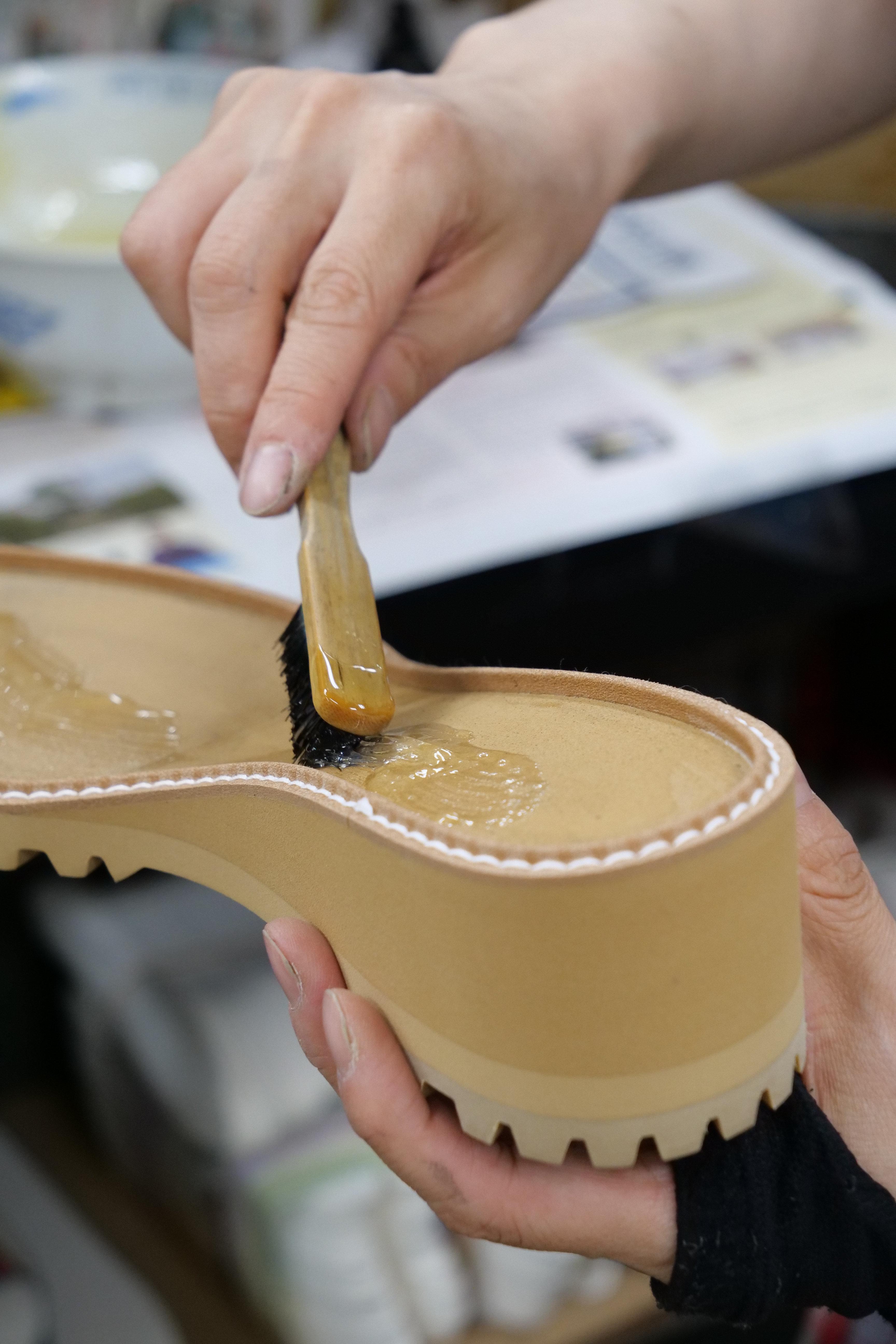 靴底に接着剤を塗る手元