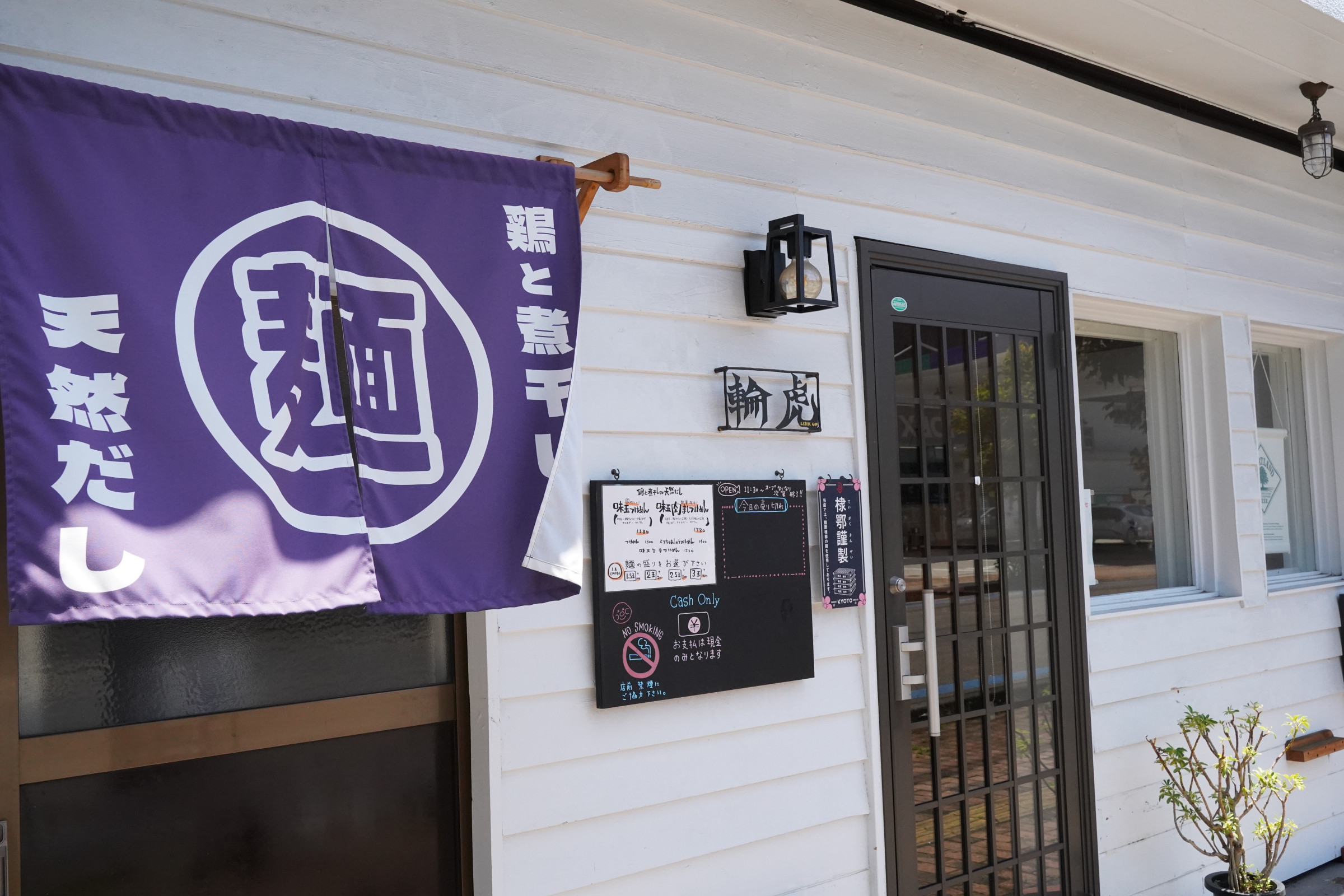 白い壁に青いのれんが目印です