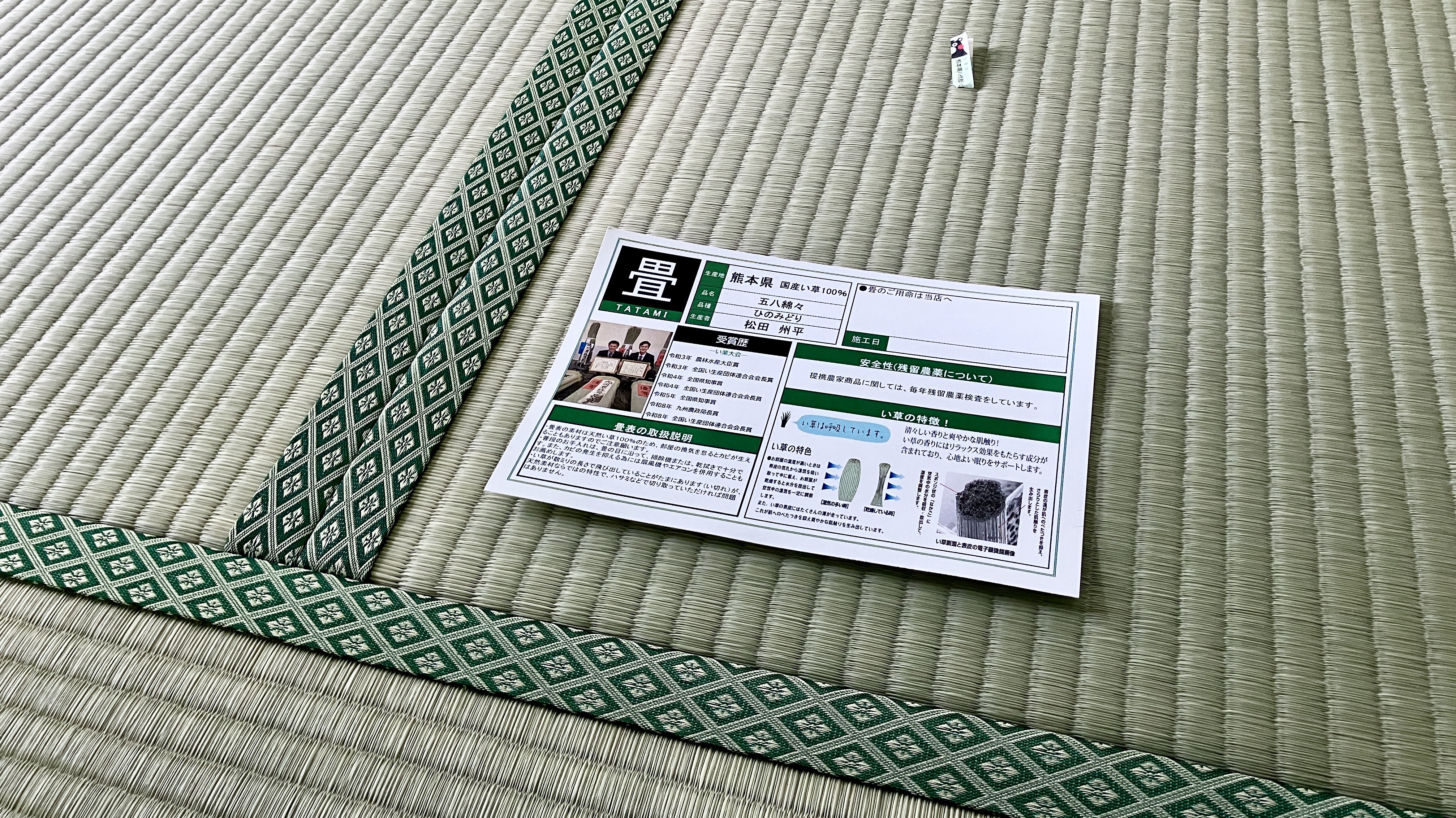 納品後の新しい新畳。名匠・松田州平氏の品質証明書と、い草に差し込まれた安心のQRタグの様子｜佐藤畳工業