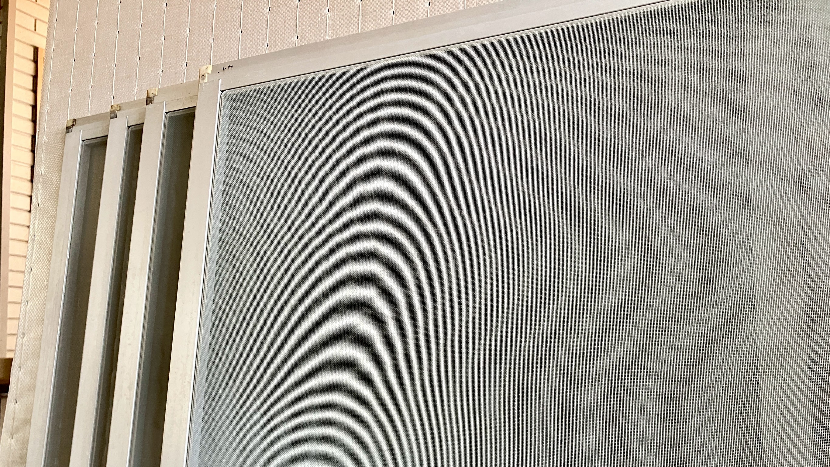 桐生市菱町のお客様宅へお仕立てした、1ミリのたるみもなく美しく張り替えられたグレーの高級網戸の写真｜佐藤畳工業
