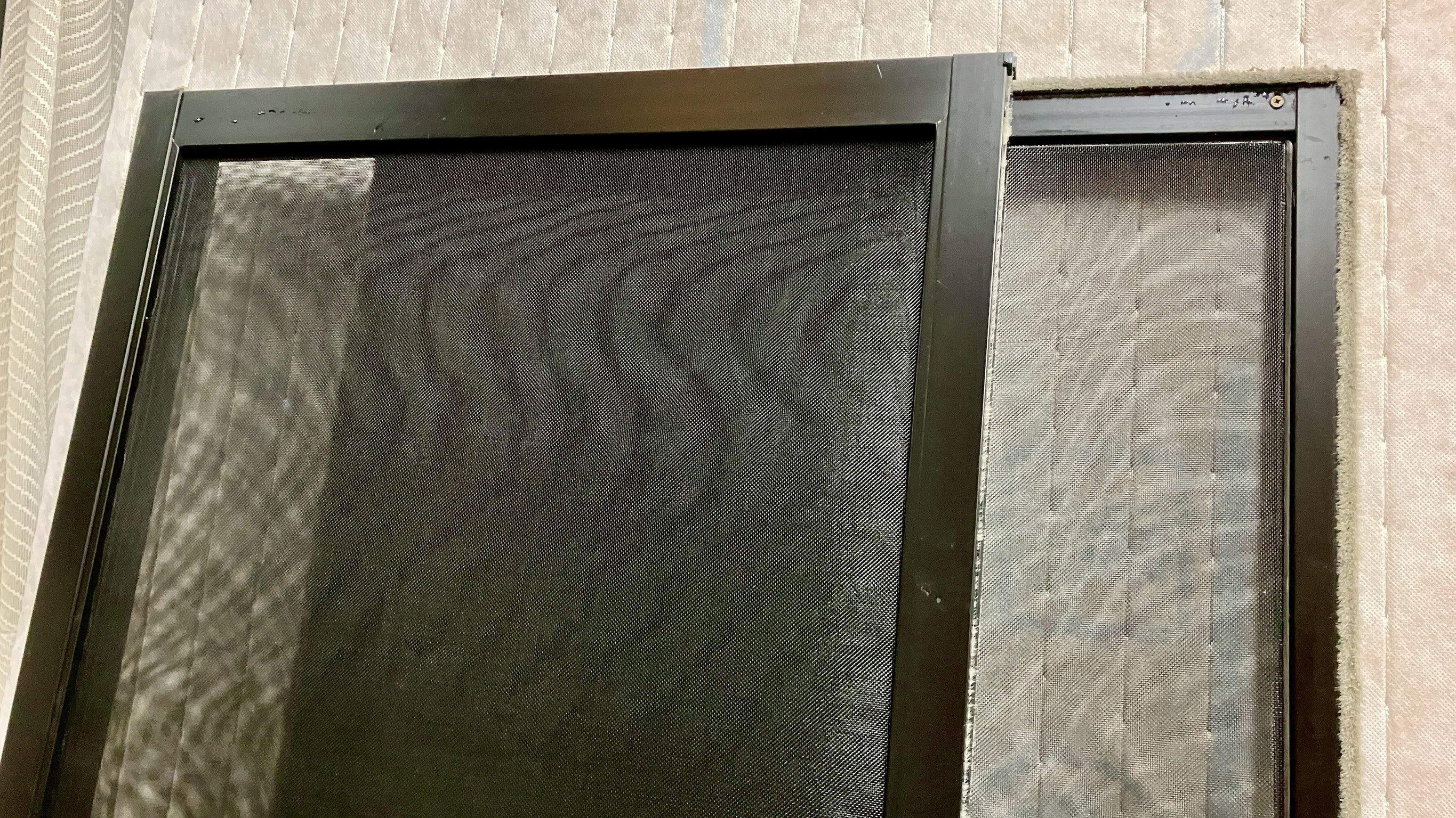 お客様より当店の仕事場へ直接お持ち込みいただいた、24メッシュ黒網で綺麗に張り替えた網戸の写真｜佐藤畳工業
