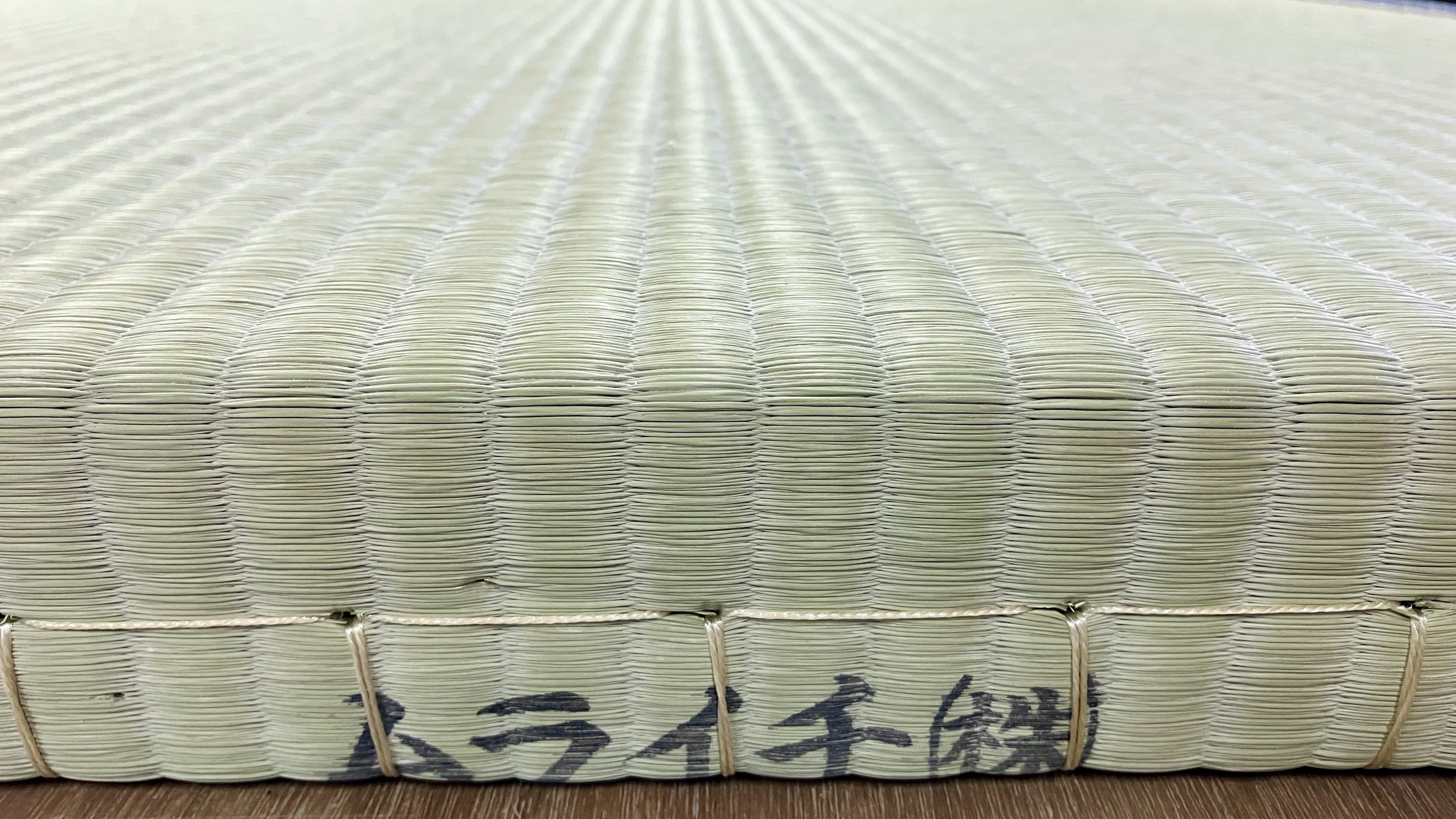 熊本県の出荷元であるムライチ株式会社の刻印が堂々と刻まれた国産新畳の側面写真｜佐藤畳工業