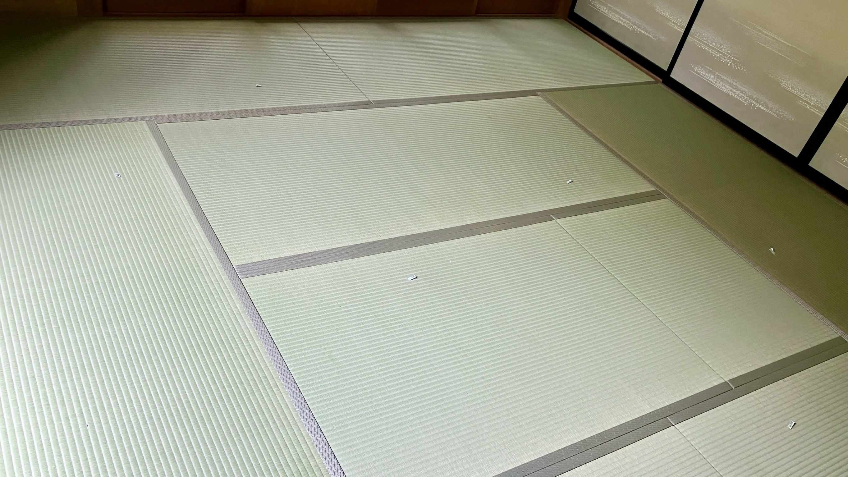 4尺5寸の掘りごたつの枠に合わせて中央の畳が美しく分割されお部屋の四隅までピシッと敷き詰め完了した新畳8畳間の写真｜佐藤畳工業