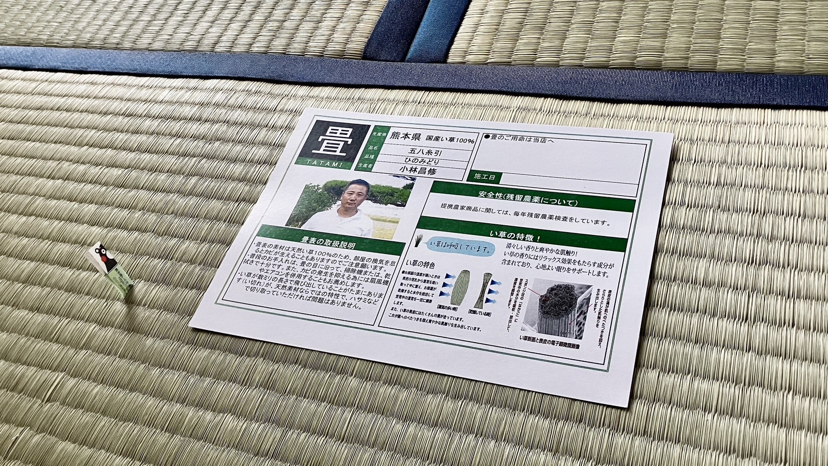 新しく綺麗に納品された青畳の上に置かれた生産者小林昌修氏のひのみどり五八糸引品質証明書のエビデンス写真｜佐藤畳工業