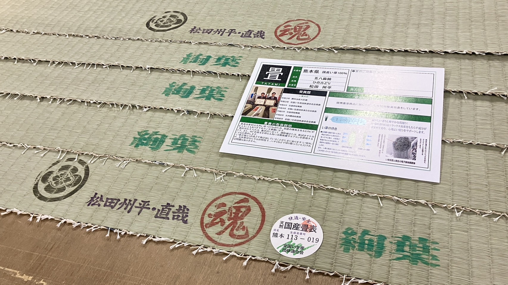 仕立てる前の名匠松田州平ブランドの絢葉刻印と熊本県産113-019の品質証明書類が置かれた使用前の高級天然国産畳表の写真｜佐藤畳工業