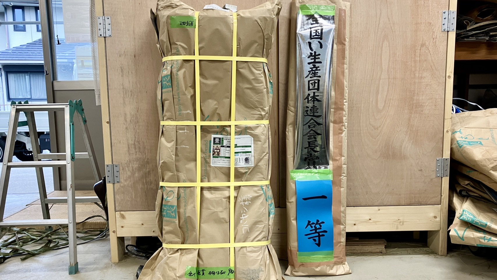 仕事場に届いた松田州平氏の畳表と全国い生産団体連合会長賞一等の公式な受賞札の写真｜佐藤畳工業