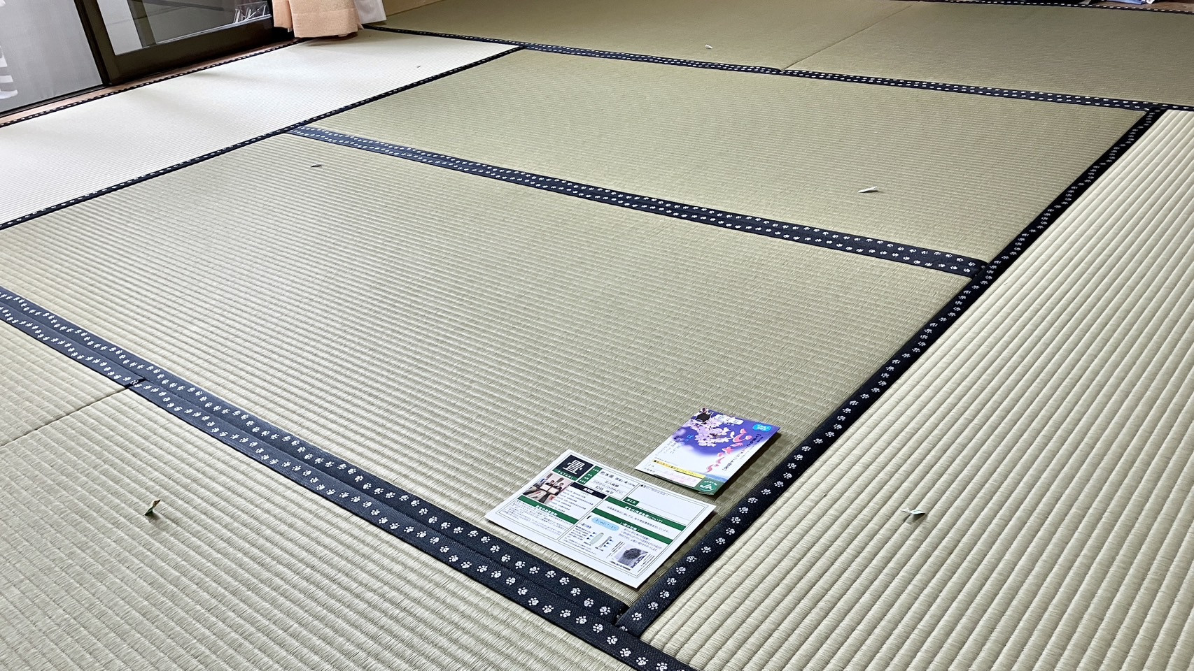 名匠・松田州平氏の高級国産畳表ひのさくらで美しく仕上げられた和室の全景と手前に添えられた生産者カード品質証明書の写真｜佐藤畳工業