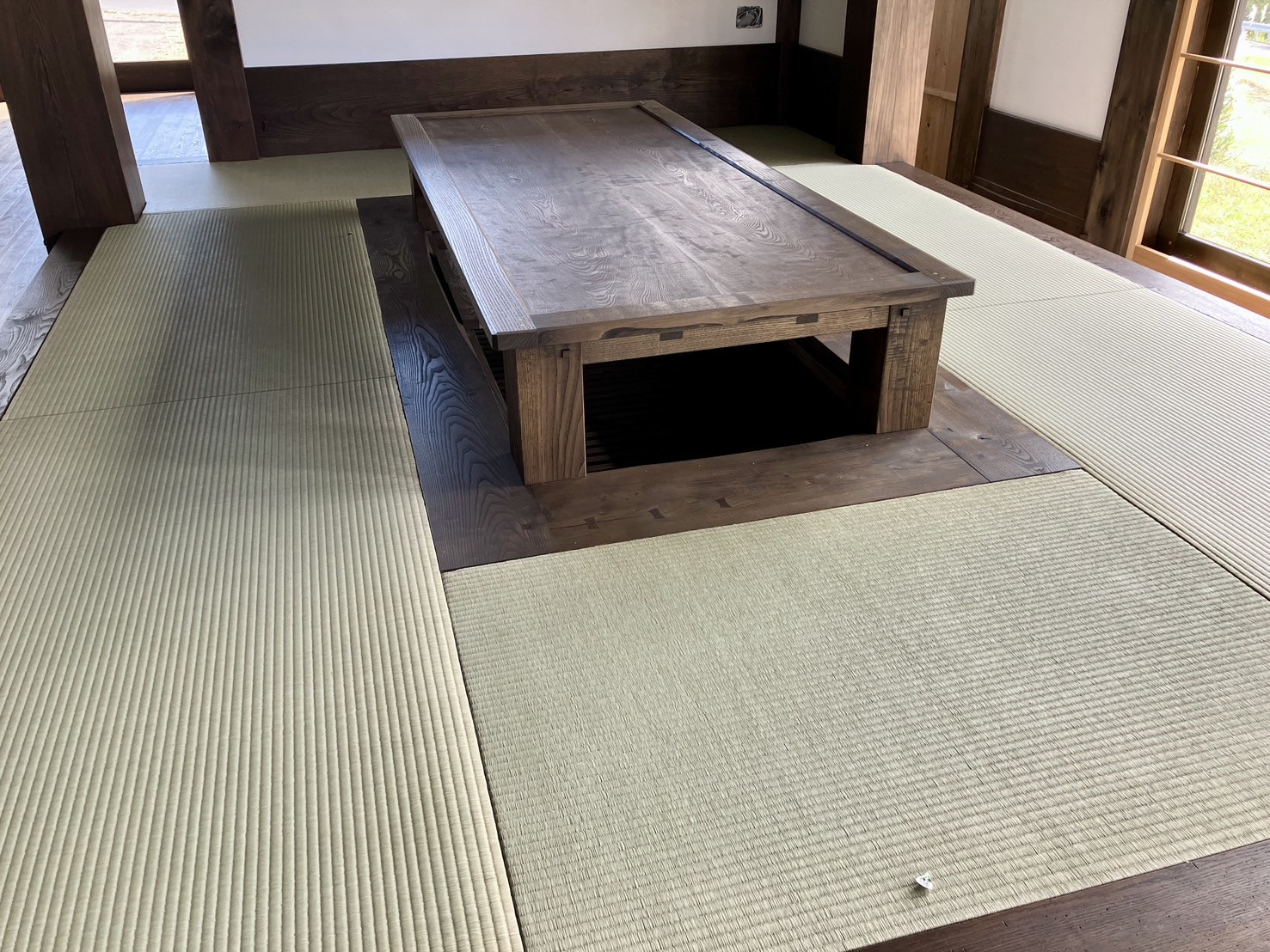 【施工後】重厚な無垢の掘りコタツを囲むように1ミリの隙間もなくビシッと格子状に敷き詰められた1畳敷き縁なし畳の和室写真｜佐藤畳工業