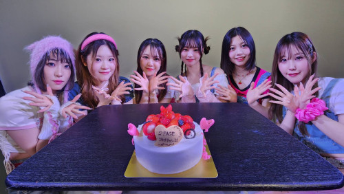 サプライズケーキと記念撮影するメンバー.jpg