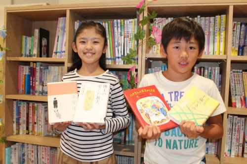 ことばの学校　男の子と女の子　本を持って立っているシーン.jpg