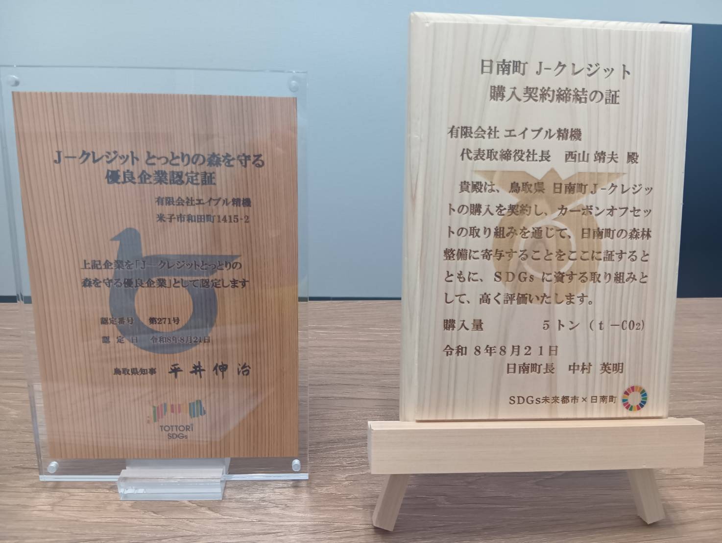 J-クレジット とっとりの森を守る優良企業認定証と、日南町J-クレジット購入契約締結の証