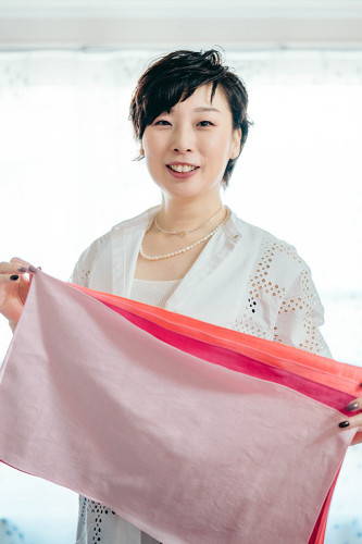 イメチェン後のサロンオーナー。ショートヘアでクールな装い。元気な笑顔が個性にマッチして自然な印象。