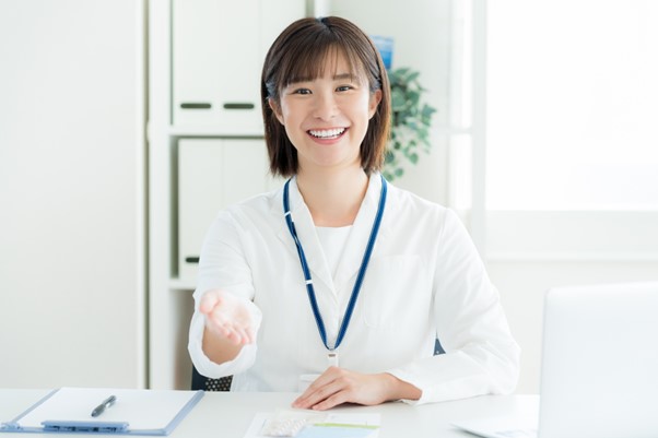 笑顔で書類を差し出す女性スタッフ