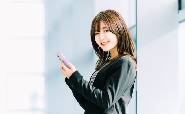 スマートフォンを使うオフィスの女性