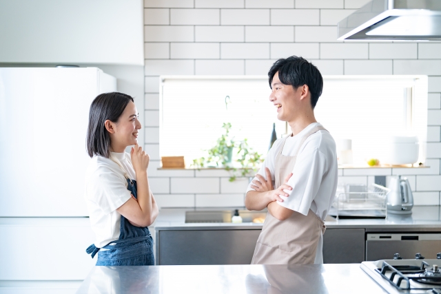 モダンキッチンで会話する若いカップル