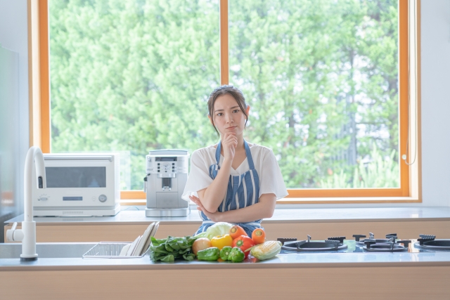 窓辺で料理を考える主婦