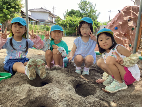 園庭で砂遊びをする子どもたち