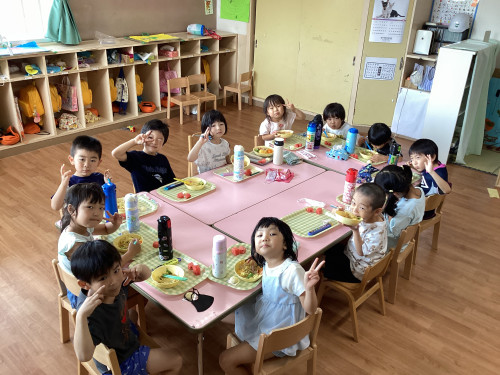 テーブルを囲んで給食を食べる子どもたち