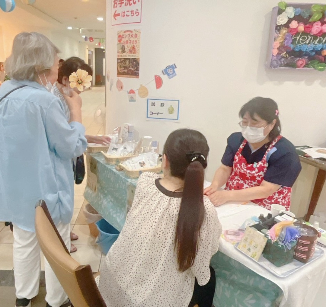有料老人ホームの夏祭りマルシェで生徒さまを応援する様子
