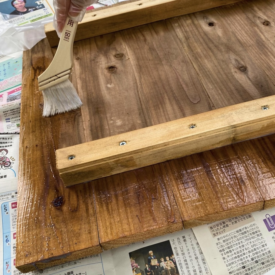コンポストの木のふたにニスを塗る作業