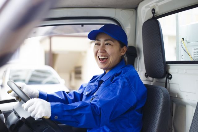 笑顔で運転をする女性ドライバー