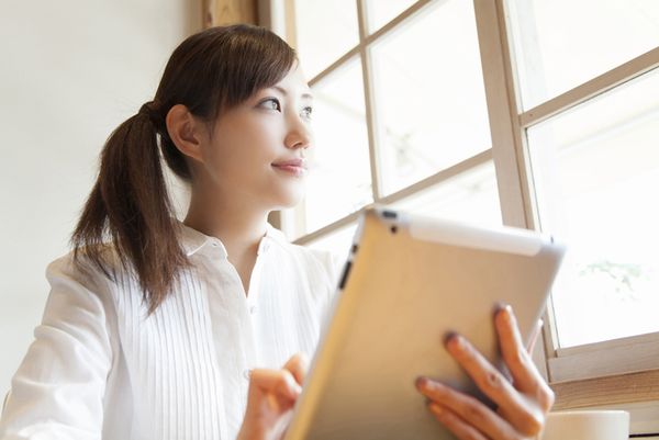 窓に向かって売り上げか伸びることを確信している若い女性の画像