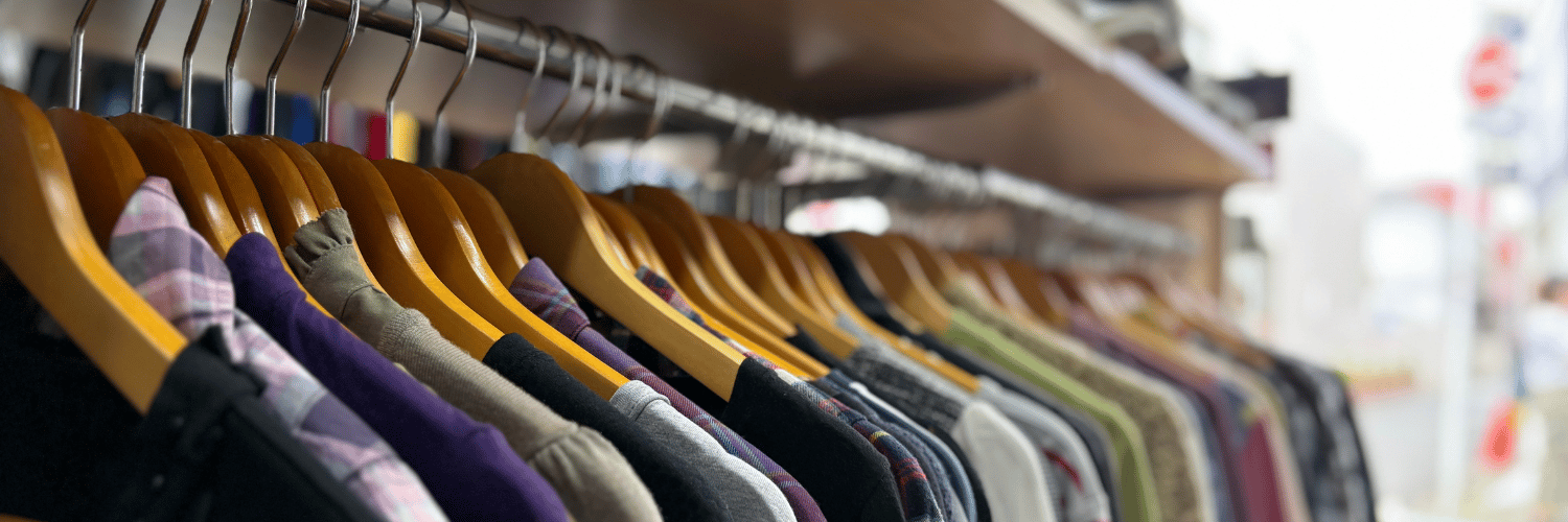 ハンガーに並ぶさまざまな洋服の店内風景